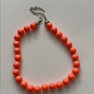 Salmon colored necklace.